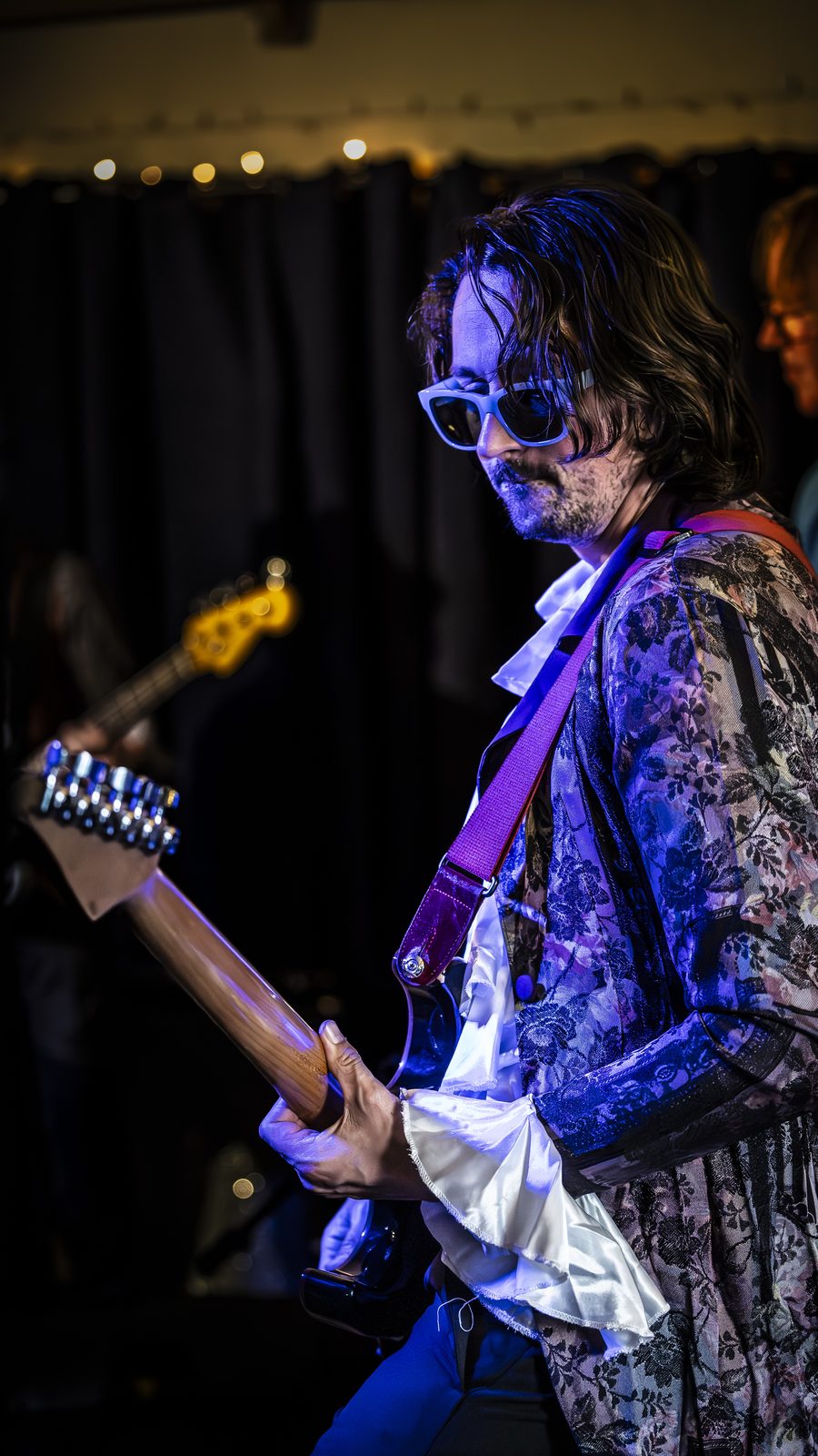 Mike Lurincic in purple stage light with floral jacket