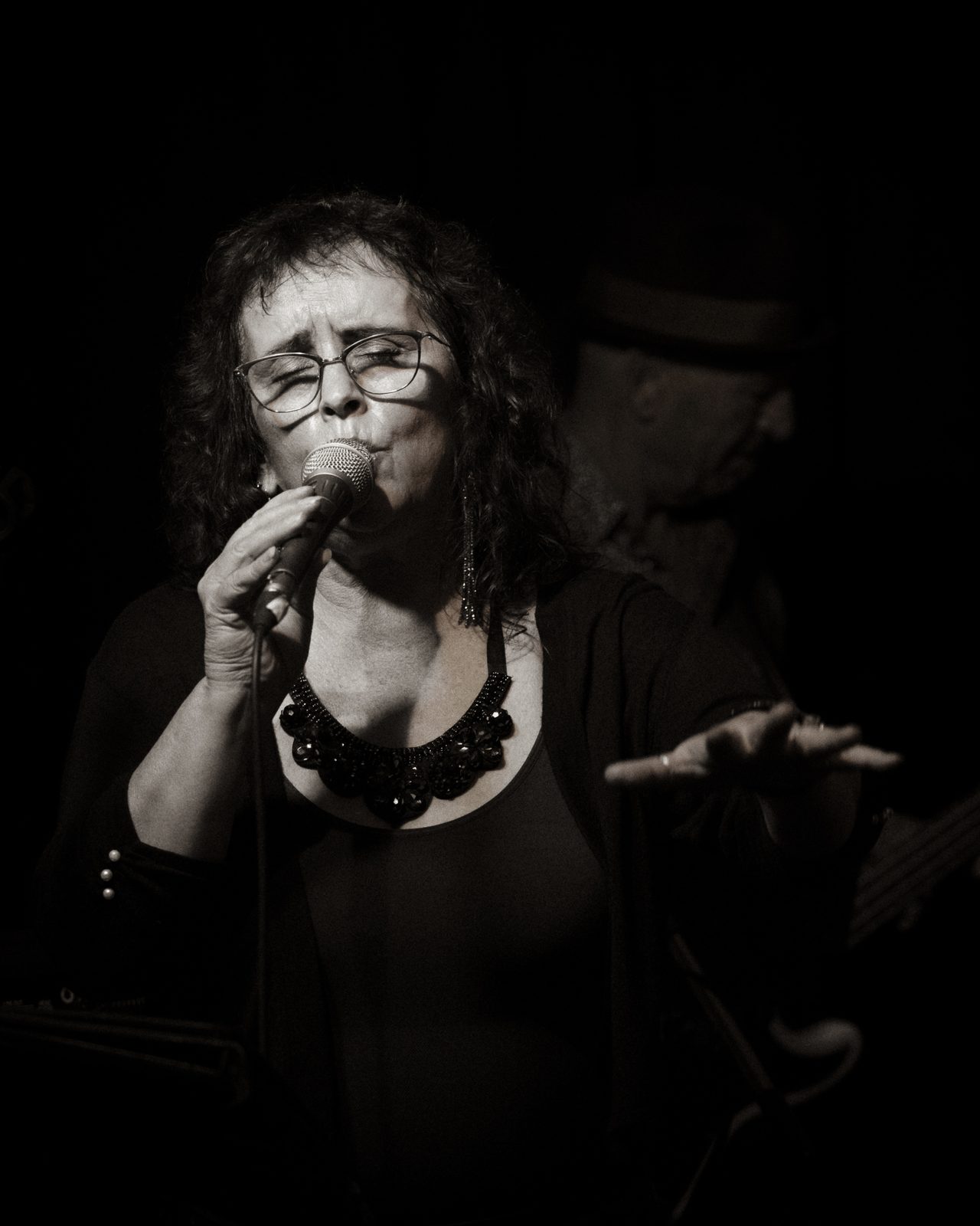 Sherry Leigh Williams singing into the microphone, black and white