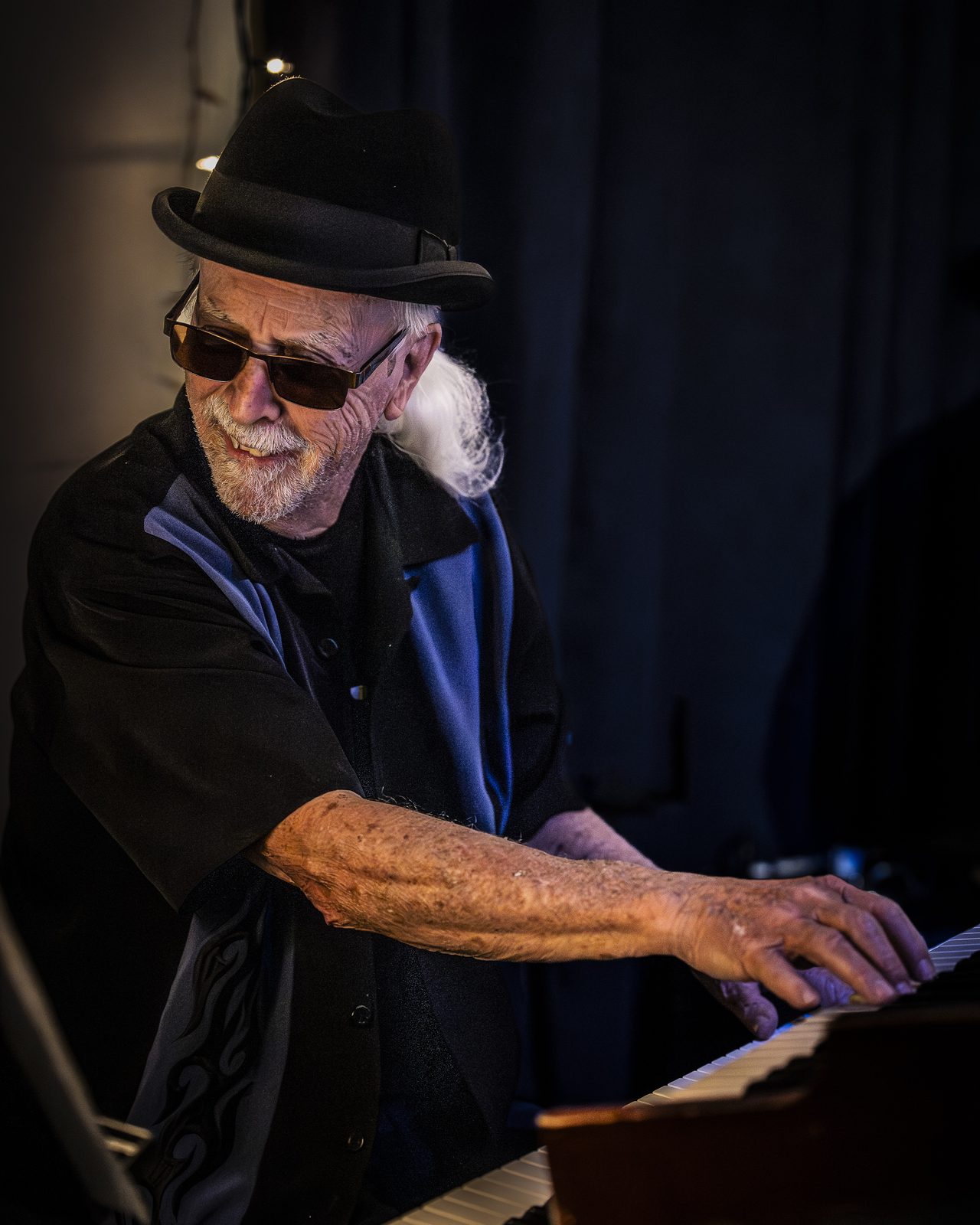 Wilf Davies at the keys, hat and shades